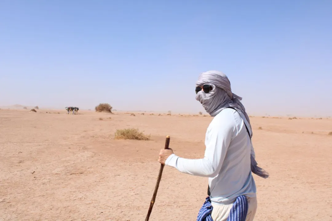 A close-up of footprints trailing across smooth desert sand, representing the journey of inner purification.
