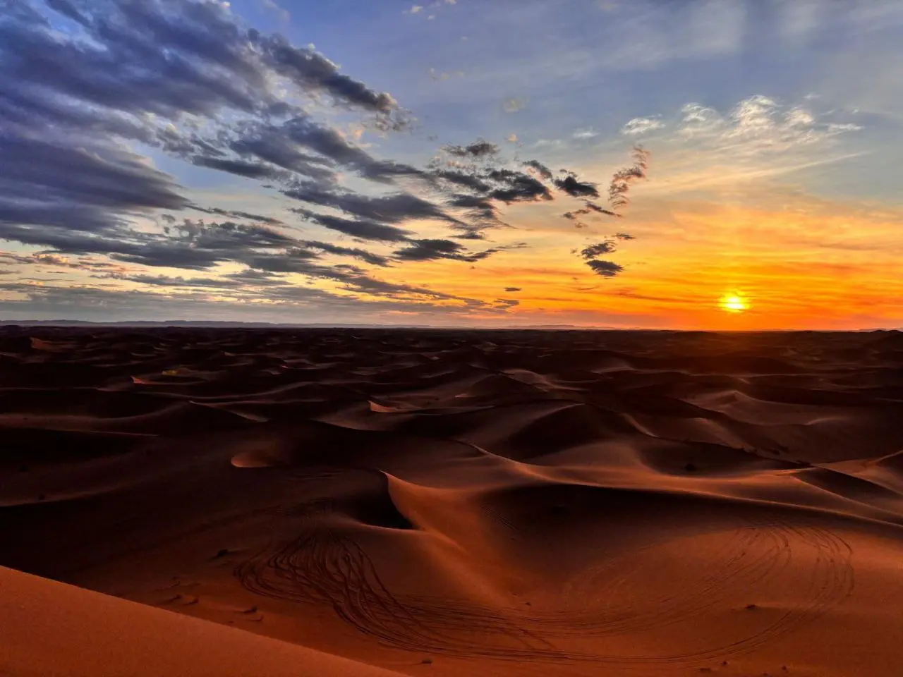 Tracks across the dunes at sunset