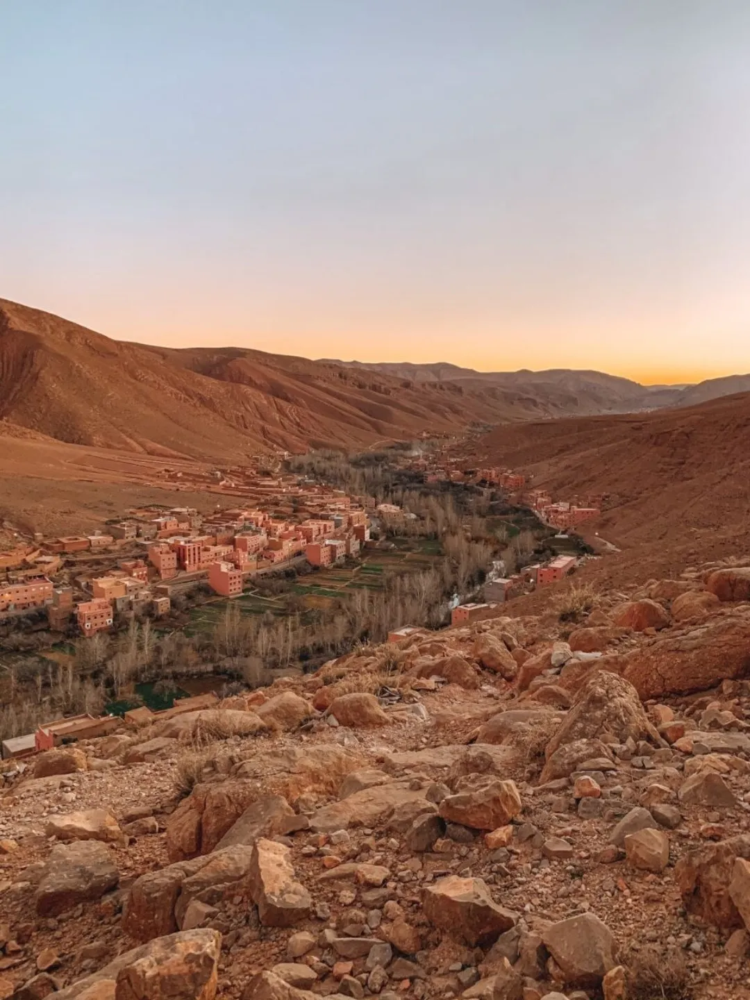 Valley village among rocky desert hills at sunset